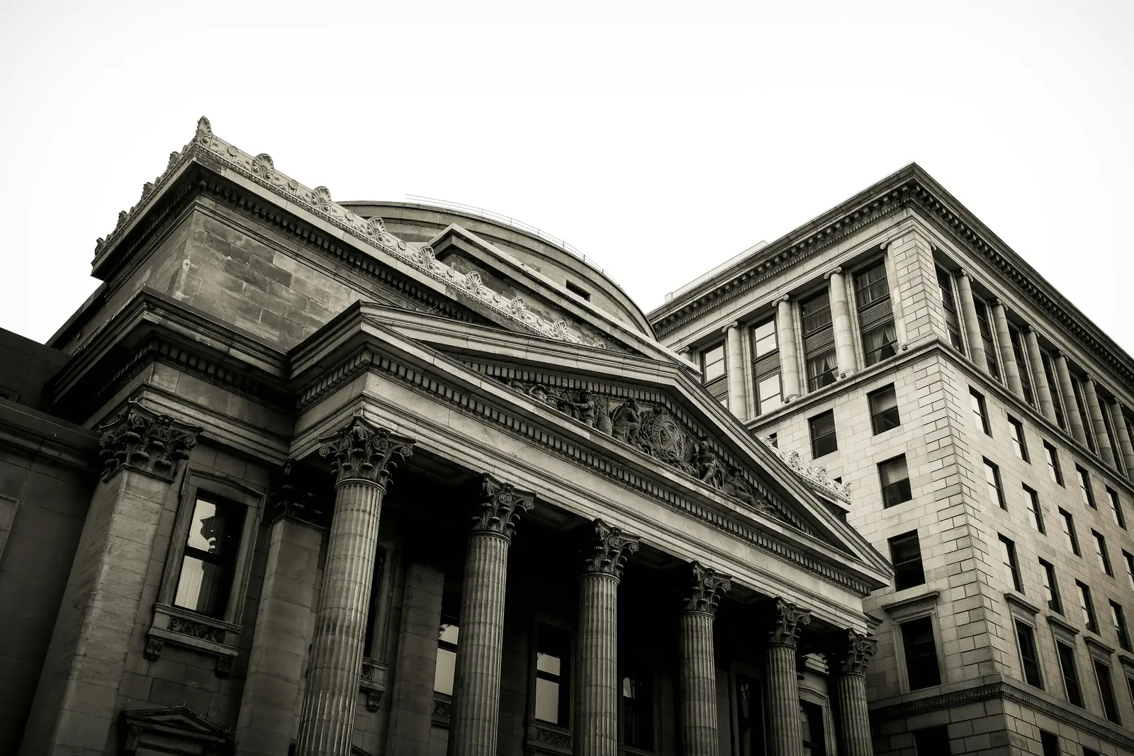 Classical stone bank building with tall columns seen from below